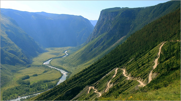 Vallée fluviale entre montagnes vertes accidentées